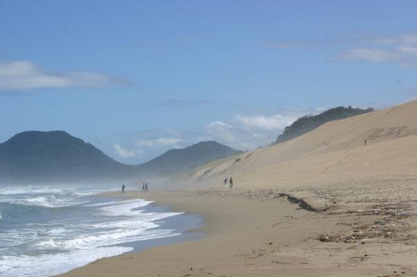 波しぶきと巻き上がる砂で霞む海岸線