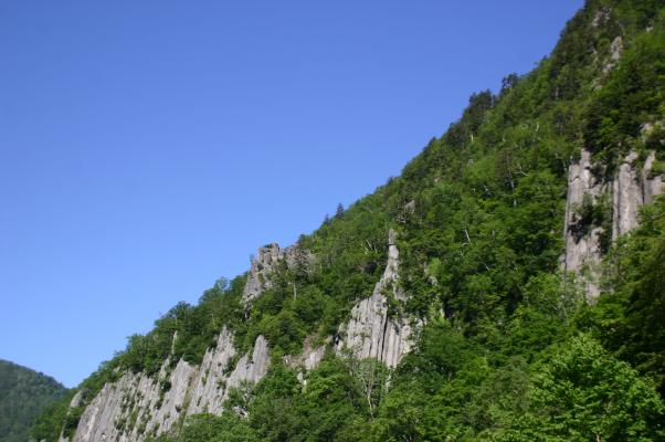 朝の青空に浮き立つ渓谷の岩壁美