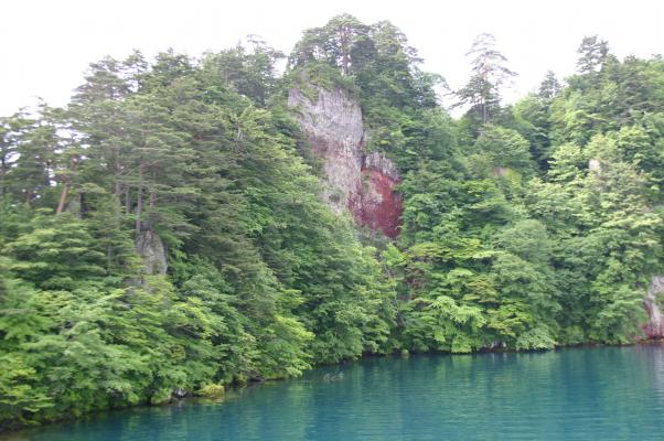 十和田湖の青い湖面と赤い岩