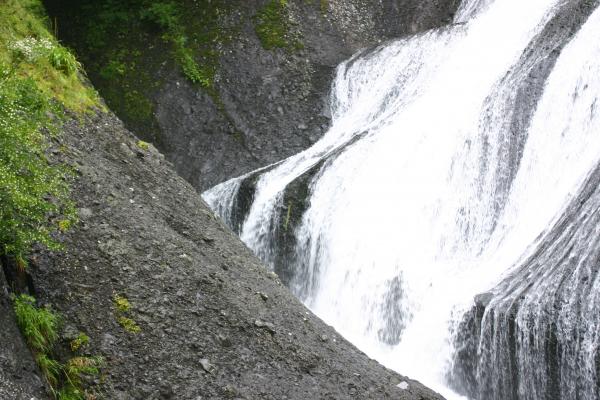 黒褐色の岩壁を流れ落ちる「袋田の滝」