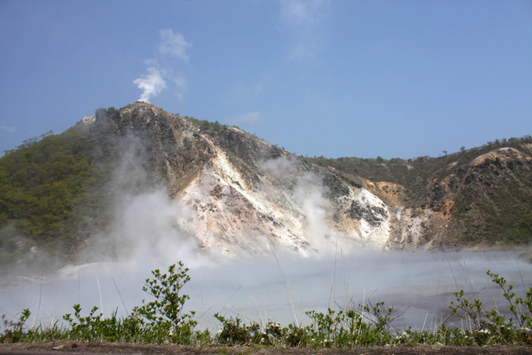 活火山「日和山」の爆裂火口沼の湯煙と頂上の白煙