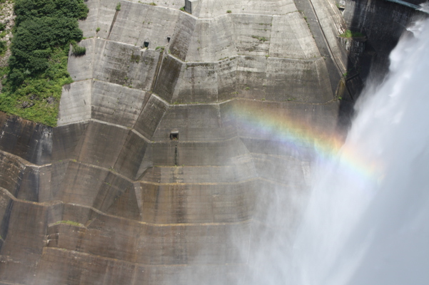 黒部ダムの放水と水煙と虹