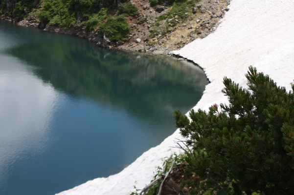 積雪の縁とコバルトブルーの湖面
