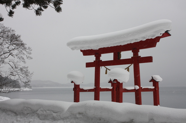 積雪の田沢湖畔と「御座石神社」鳥居