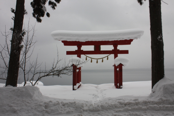 積雪の田沢湖畔と「御座石神社」の鳥居