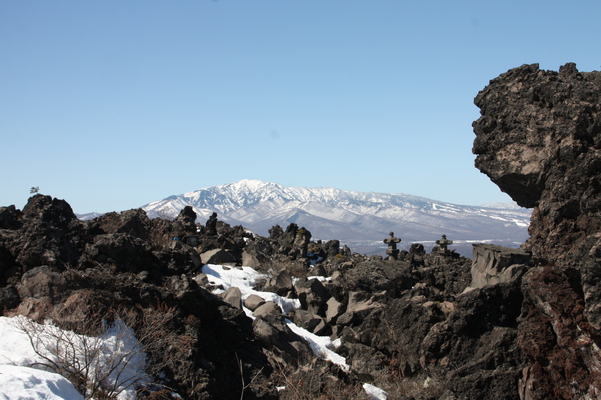 積雪の溶岩原と山並み