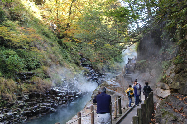 秋の小安峡「岩間からの噴泉と湯煙」と遊歩道の人々