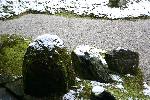 雪積もる庭園内の石