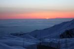 積雪の立山から見た雲海に沈む夕日