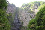 夏の阿蘇「古閑の滝」の断崖と緑の森