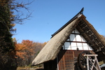 秋の紅葉と茅葺き水車小屋